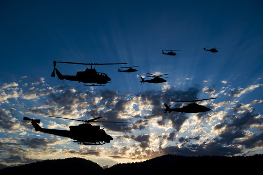 Flying army helicopters on sunset background