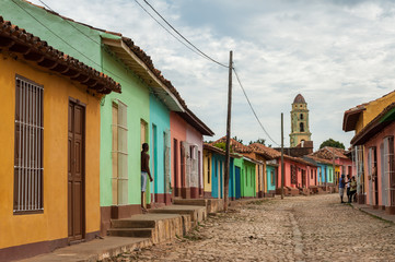 Fototapeta na wymiar Colored houses on a cobblestone street in colonial Trinidad, Cub