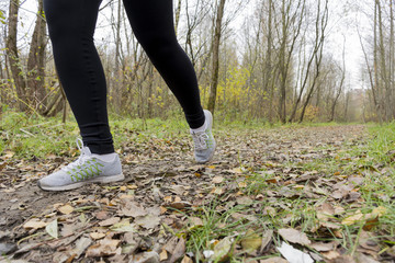 the girl athlete in sneakers and leggings running along the path