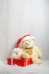 Teddy bear in santa hat with gifts