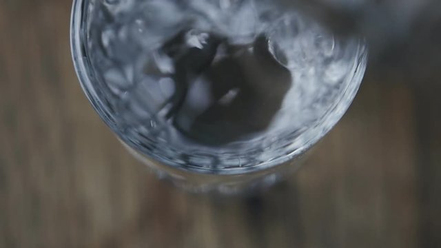 Close up of Pouring vodka in glass in slow motion