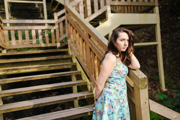 girl sitting on the wooden stairs in park and smiling