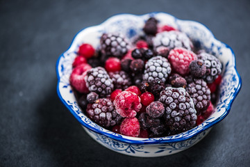 Bowl with frozen black forest fruits