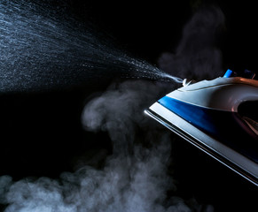 Iron with steam and water stream  isolated on a black background
