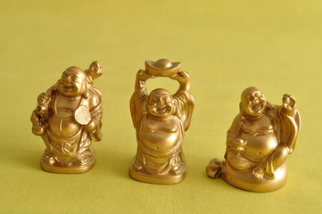 Figurines of a laughing and cheerful golden Buddhas