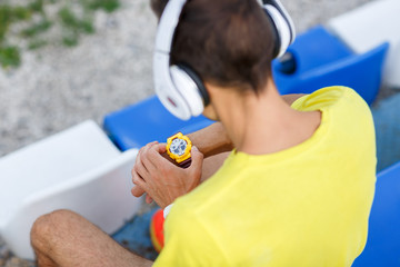 Young sportsman sitting in stadium with headphones