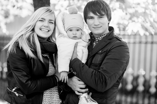 Young family with baby in autumn park. black - white photo