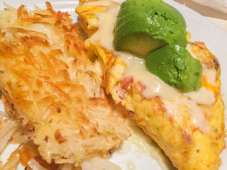 Traditional breakfast: omelet with avocado and hash brown