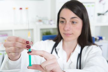 Junge Ärztin zieht Spritze mit Impfstoff auf