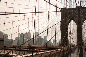 Brooklyn Bridge with no people on a rainy day with Manhattan skyline