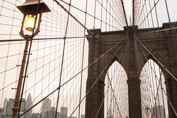 Naklejka premium Brooklyn Bridge with lamp post in the foreground