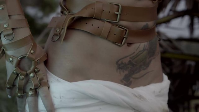 Closeup hand and stomach of beautiful amazon woman warrior adjusting her swordbelts before the fight or hunt