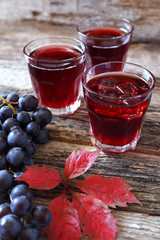 Grape juice, black grapes and autumn leaves