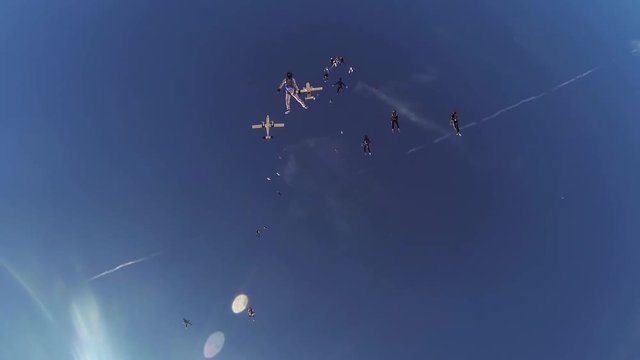 Skydivers jump from airplane above arizona. Adrenaline. Make formation in sky. Landscape.