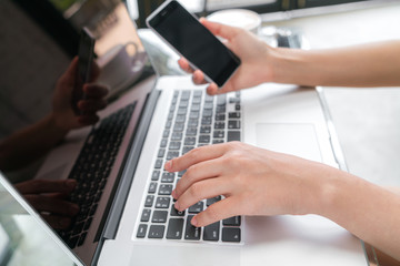 Fototapeta na wymiar Closeup of business woman hand typing on laptop keyboard with mo