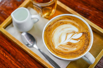 Latte Coffee art on the wooden table .
