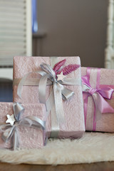 Holiday gift boxes decorated with ribbon. Beautiful purple shiny package for Christmas and New...