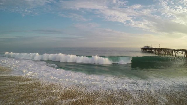 SoCal beach, aerial of crashing waves, Balboa Pier, Newport Beach, California.