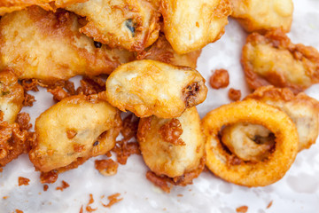 Deep fried calamari rings in cardboard takeaway.