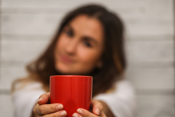 Beautiful young girl with a red Cup in hand