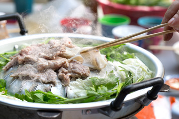 Grilling sliced pork and meat on hot pan asian style / selective