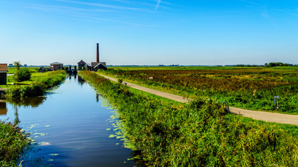 Naklejka premium The historic Nijkerk Pumping Station or Nijkerk's Gemaal at Veluwemeer under blue sky near the town of Nijkerk in the Netherlands