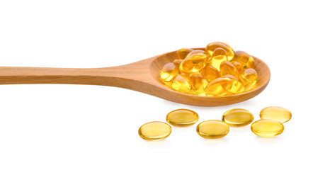 Fish oil pill in wooden spoon isolated on white