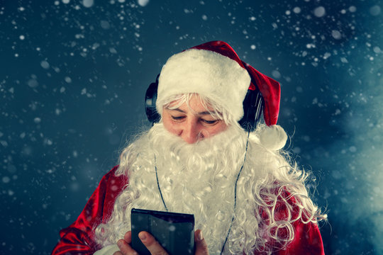 Authentic Santa Claus is listening to music.