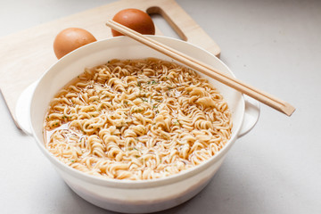 boil instant noddles with eggs on the white table