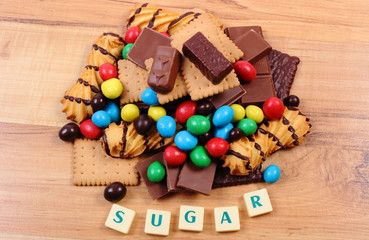 A lot of sweets with word sugar on wooden surface, unhealthy food