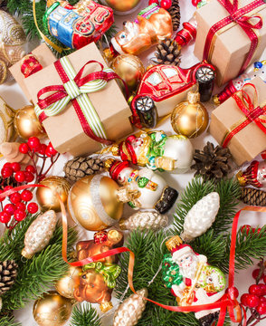 Christmas or New Year background: fur-tree, branches, gifts, colored glass balls and toy, decoration and cones on a white background