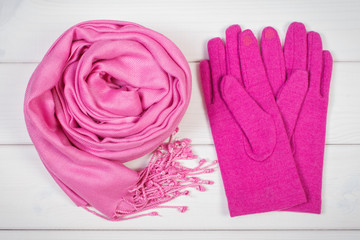 Pink shawl and gloves for woman on boards, clothing for autumn or winter