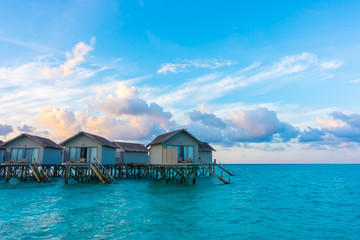 Fototapeta na wymiar Beautiful sunrise with water villas in tropical Maldives islan