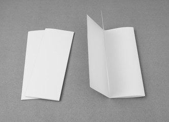 Four - fold white template paper on gray  background .