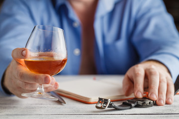 Relaxation concept - a glass of brandy in male hands. Selective