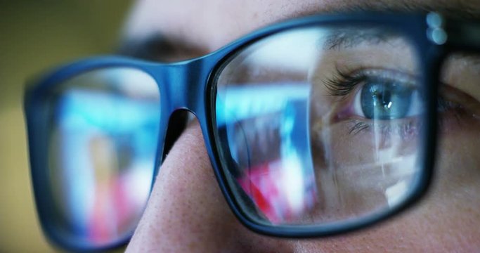 Close up of young businessman with blue eyes wearing the glasses looking on the waveform lines expressed concept of stock market, growth stock market, economic profits, stock exchange 