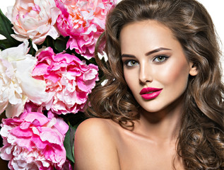 Beautiful face of young  woman over the pink flowers.