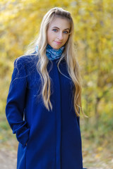 Girl in a Blue Coat in the yellow autumn background