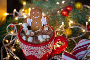 Red mugs with hot chocolate and marshmallows and gingerbread cookies. Christmas holiday concept