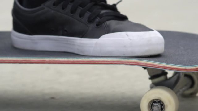 EXTREME CLOSE UP DOF: Skateboarder riding skateboard along the street
