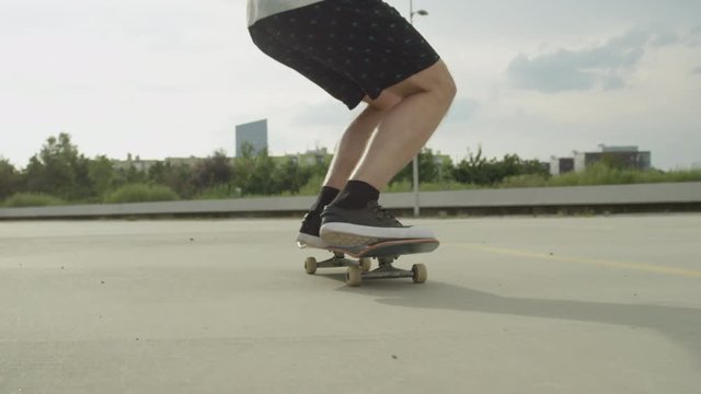 SLOW MOTION CLOSE UP: Skateboarder skating and jumping ollie tricks