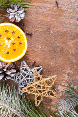 Christmas background with orange, cloves, stars and fir branches on wooden background