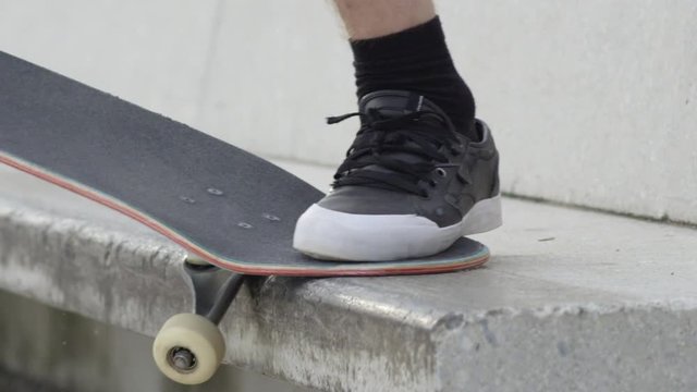 SLOW MOTION EXTREME CLOSE UP: Skateboarder sliding with skate on concrete bench