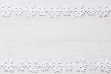 Christmas soft snowflakes on a wood white  background. New Year frame background.