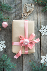 Fototapeta premium Christmas gift with pink ribbon and grey sweater on wooden surface. Overhead view. Christmas consept.