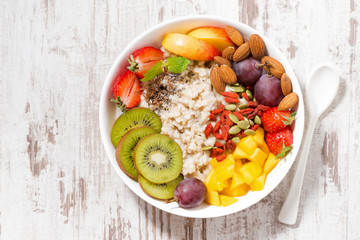 plate of oatmeal porridge with fresh fruit and superfoods