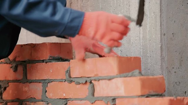 Close-up: the builder working with bricks