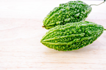 Bitter cucumber on wooden chopping board, Momordica charantia. selective focus.
