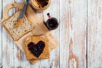Homemade peanut butter and jelly sandwich on wooden background