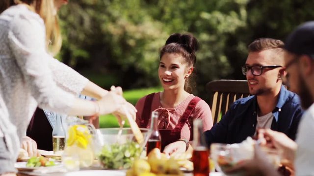 happy friends having dinner at summer garden party